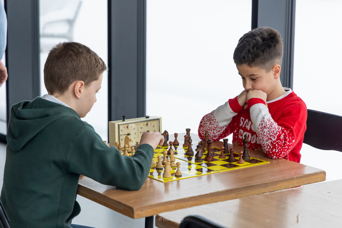 Dwaj chłopcy rozgrywają partię szachów.