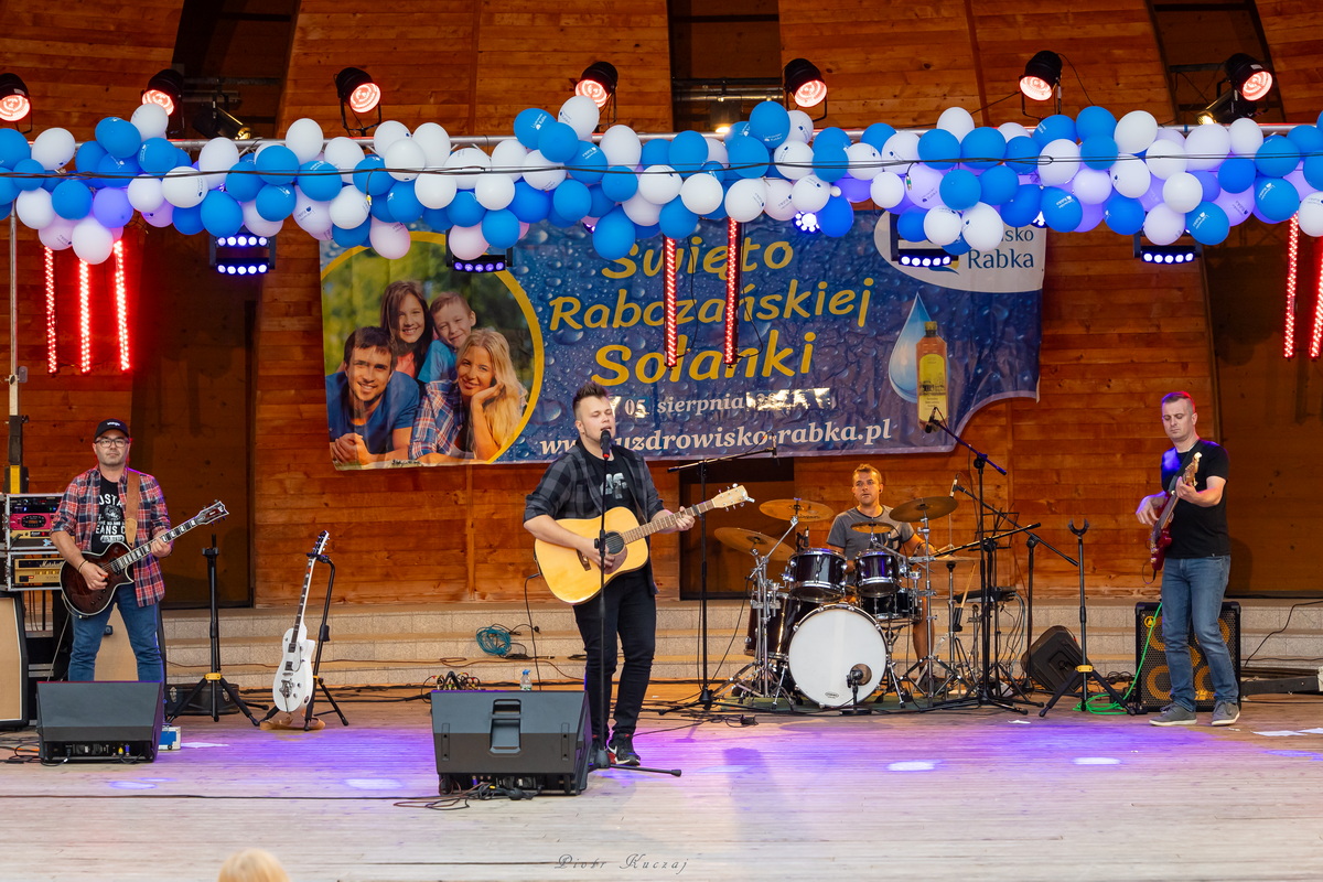 Bogdan Świerczek z gitarą na scenie.