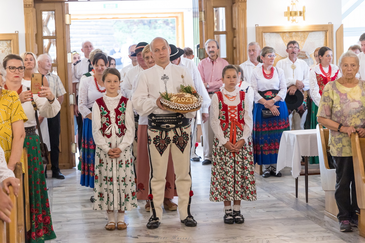 Górale w kościele z bochnem chleba.