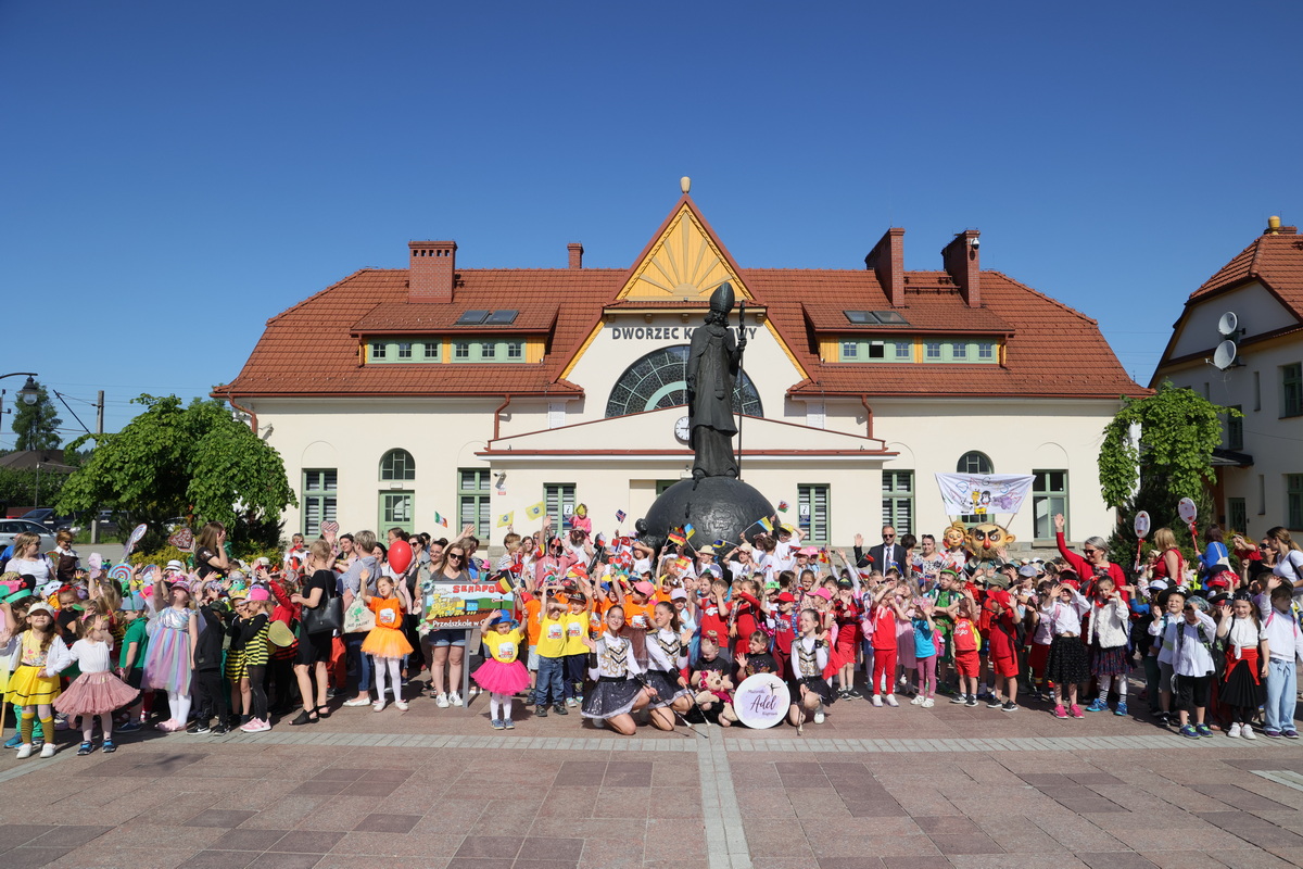 uczestnicy konkursu pod pomnikiem świętego Mikołaja przed dworcem kolejowym.