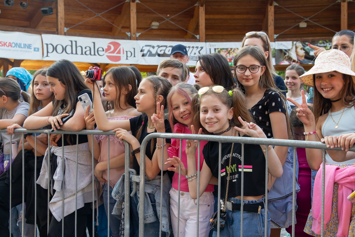 Młodzi widzowie przy barierce podczas koncertu.