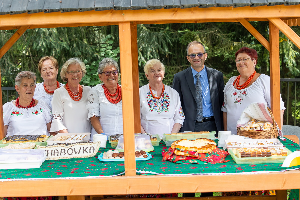 Stragan z ciastami Koła Gospodyń z Chabówki, Za nim 6 pań w towarzystwie burmistrza.