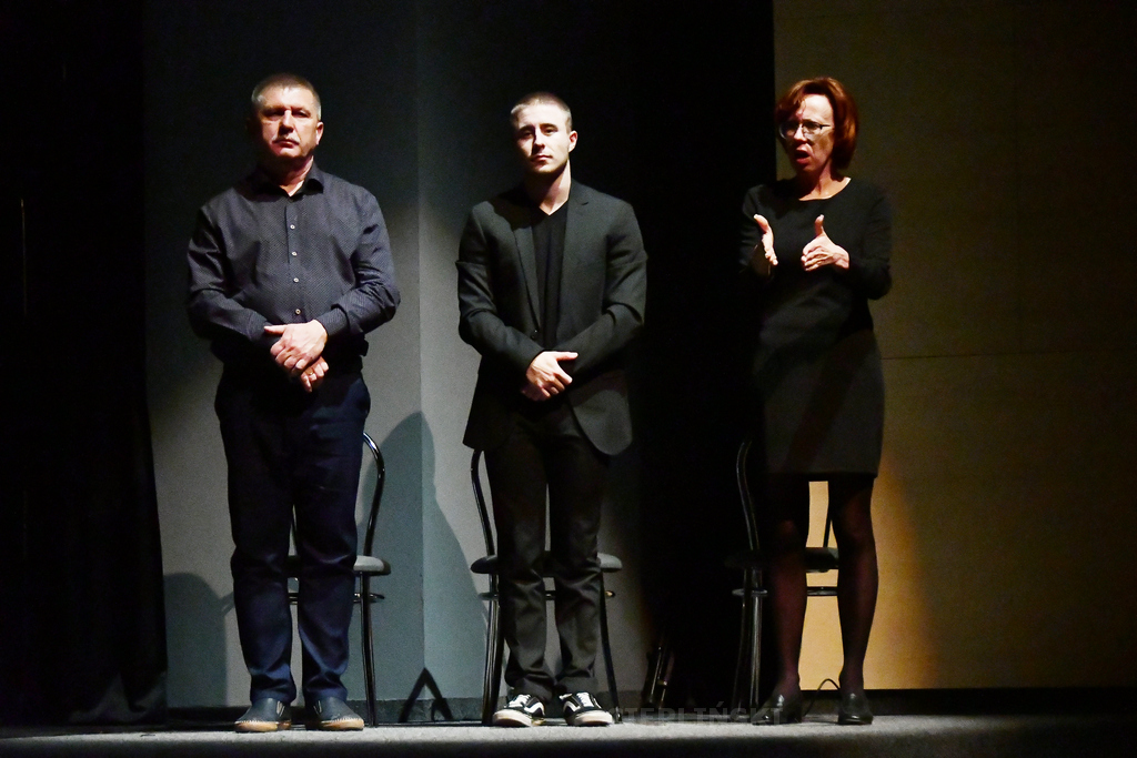 Tłumacze podczas spektaklu: wszyscy stoją, kobieta miga. Są ubrani na czarno.