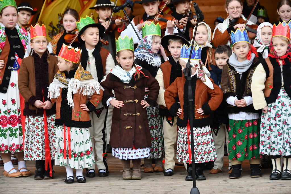 Dzieci z zespołu ludowego przebrane w tradycyjne stroje i z koronami na głowach.